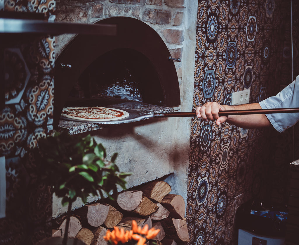 Pizza going into a stonebaked oven