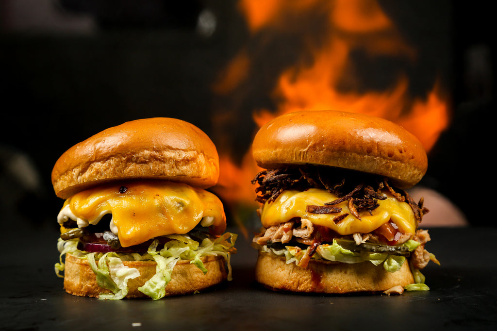 Two burgers in front of fire.