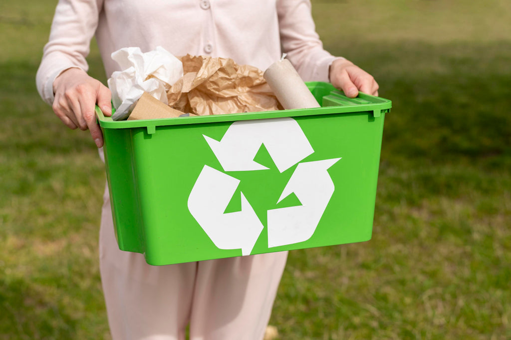 woman holding a recycling box with cardboard and paper inside