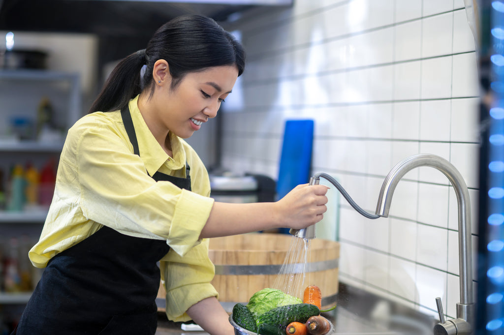 woman in the kitchen washing and preparing vegetables before cooking