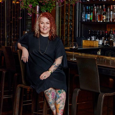 Profile of Kathleen McGivney, CEO of RedBar Group, sitting at a bar