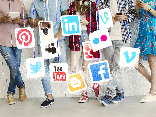 People standing behind multiple images of social media platform logos