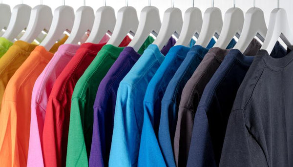 A clothing rack full of colourful T-shirts
