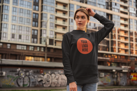 attractive woman wearing a black hoodie in front of a high rise building