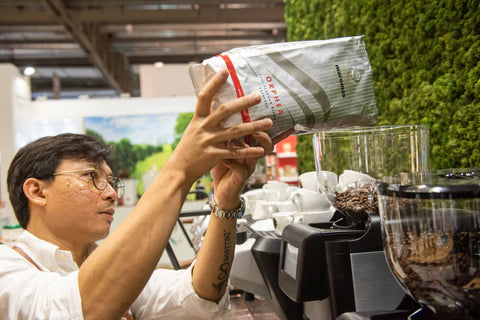 Pouring maromas beans into a grinder