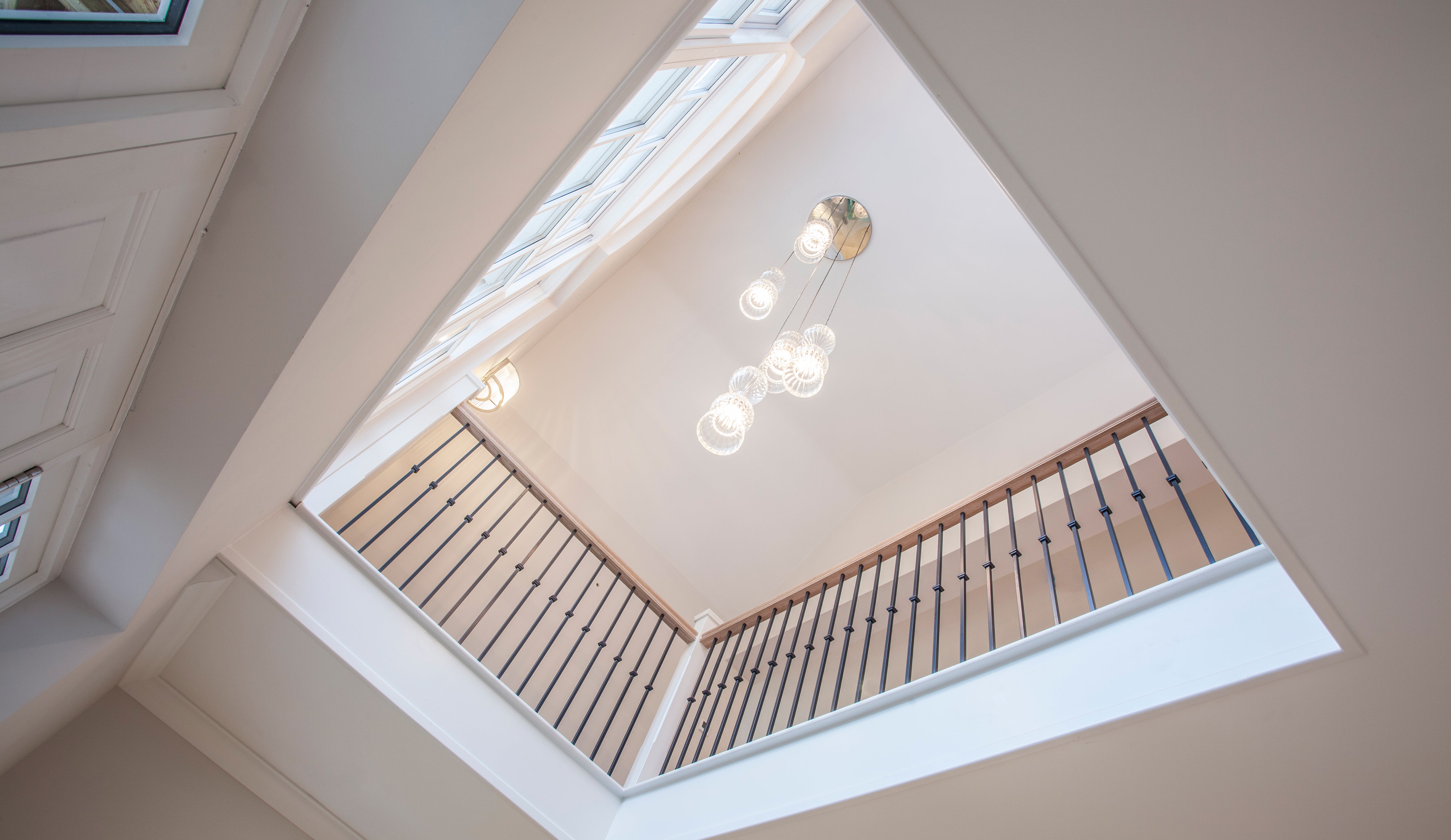 Spindle Pendant glass lights by Rothschild &amp; Bickers cascading through stairwell, interiors by Katie Elizabeth Design