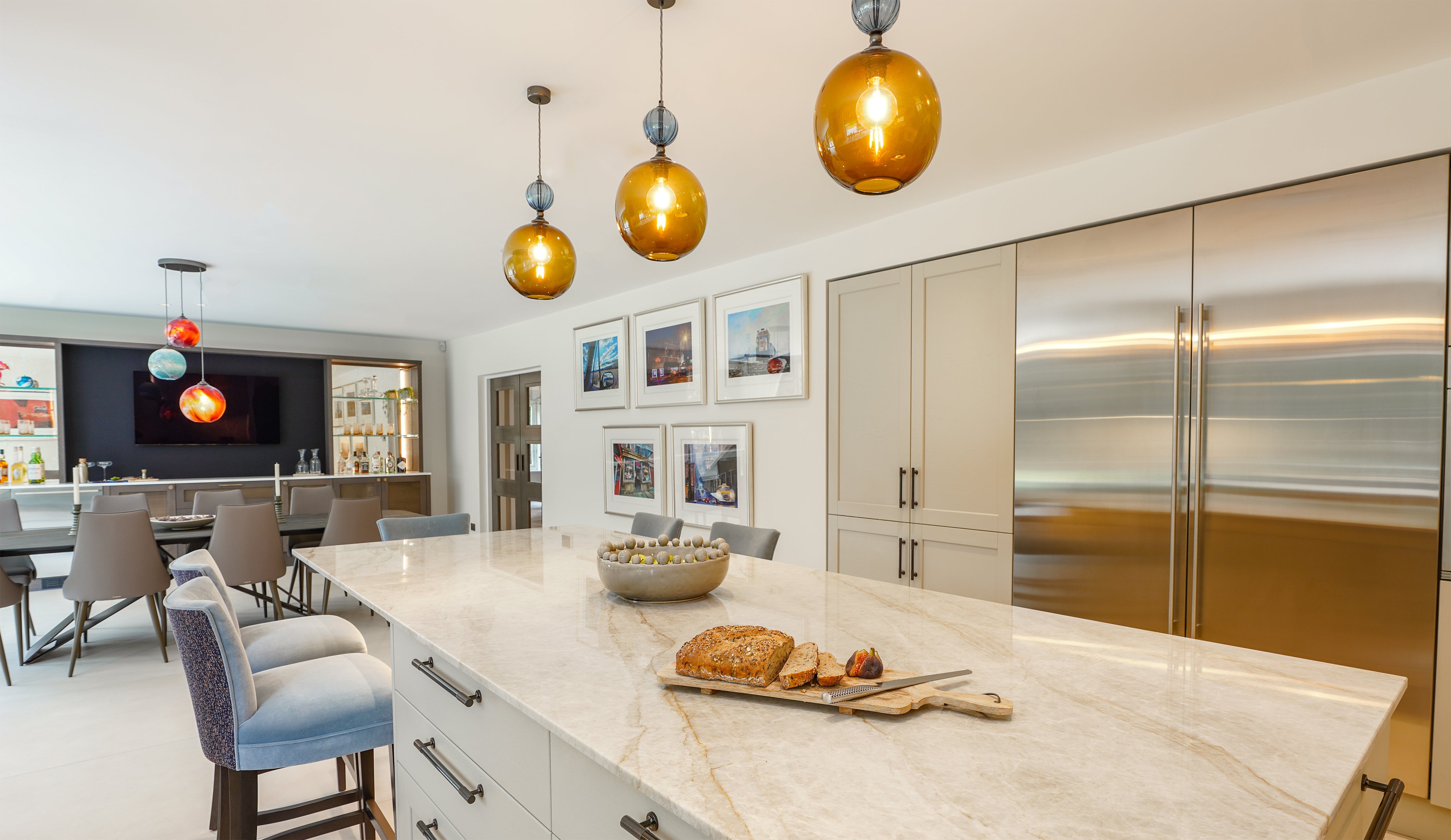 Pendant lighting by Rothschild &amp; Bickers hanging over kitchen island and dining table