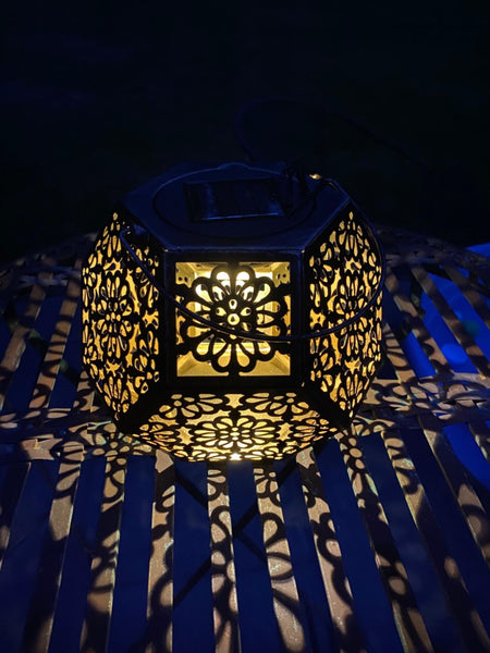 This Solar lantern is so pretty. can hang it, but I like how it shines a pattern on the table