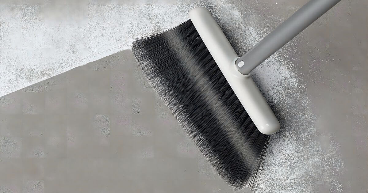 Use broom to clean debris on concrete flooring