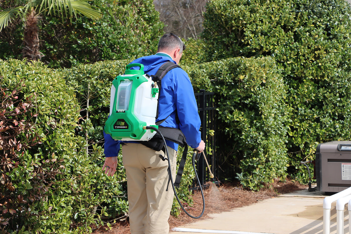 man with battery backpack sprayer spraying pool deck