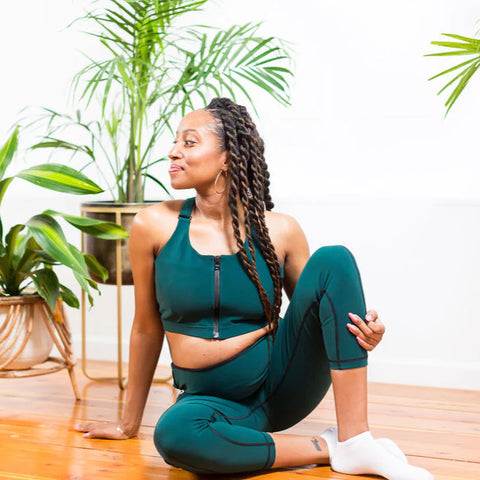 Black woman wearing a dark green activewear set