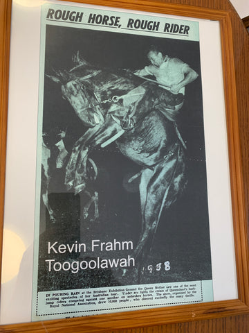 Framed newspaper image of Kevin riding a bull. Headline reads: Rough horse, rough rider.