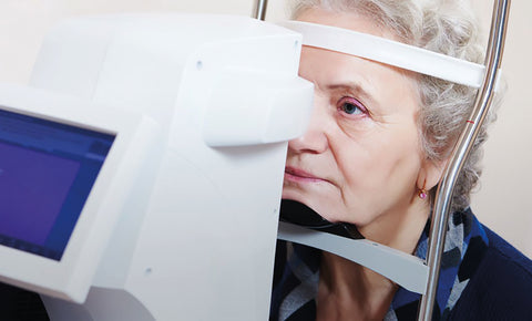 Older woman getting her eyes checked by a machine