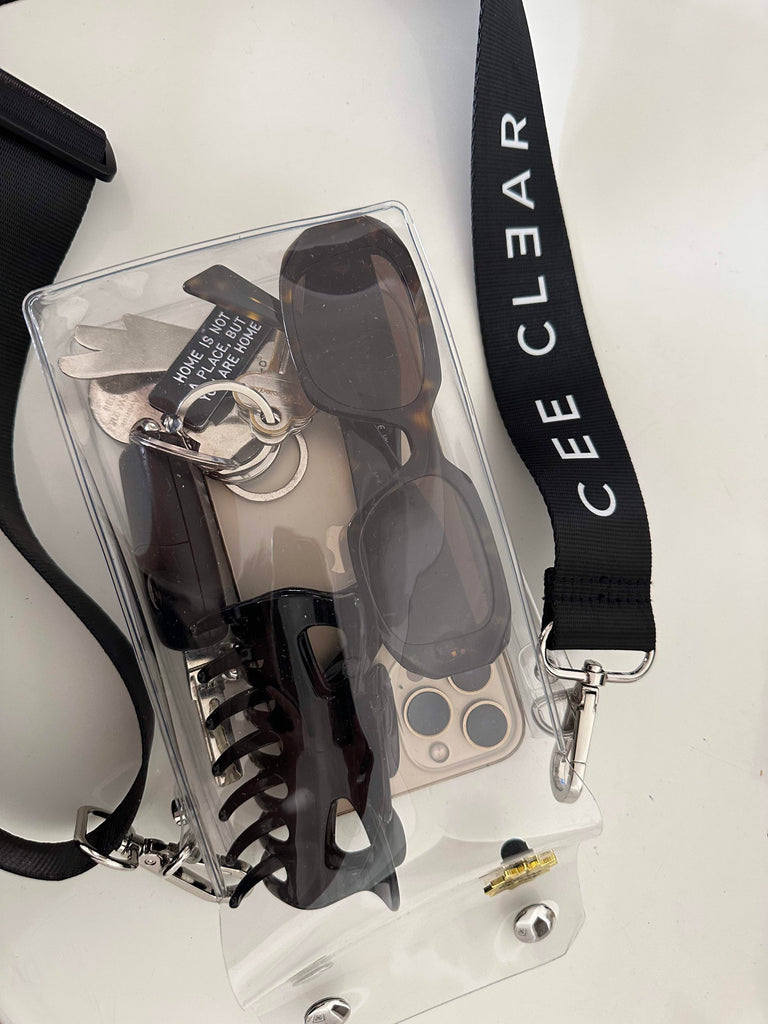 Image of CEE CLEAR Clear Cross Body Bag with hair clip, glasses and keys.