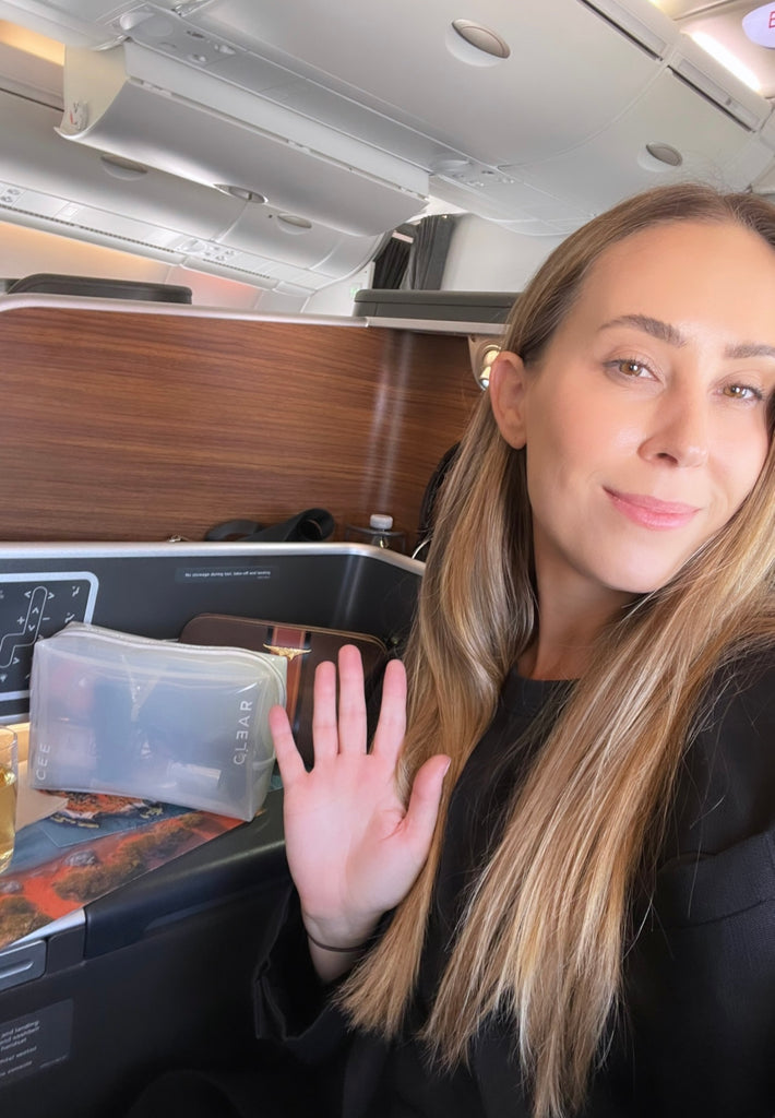 Image of CEE CLEAR founder Morgan on a plane to LA with her Milky Cosmetic Case