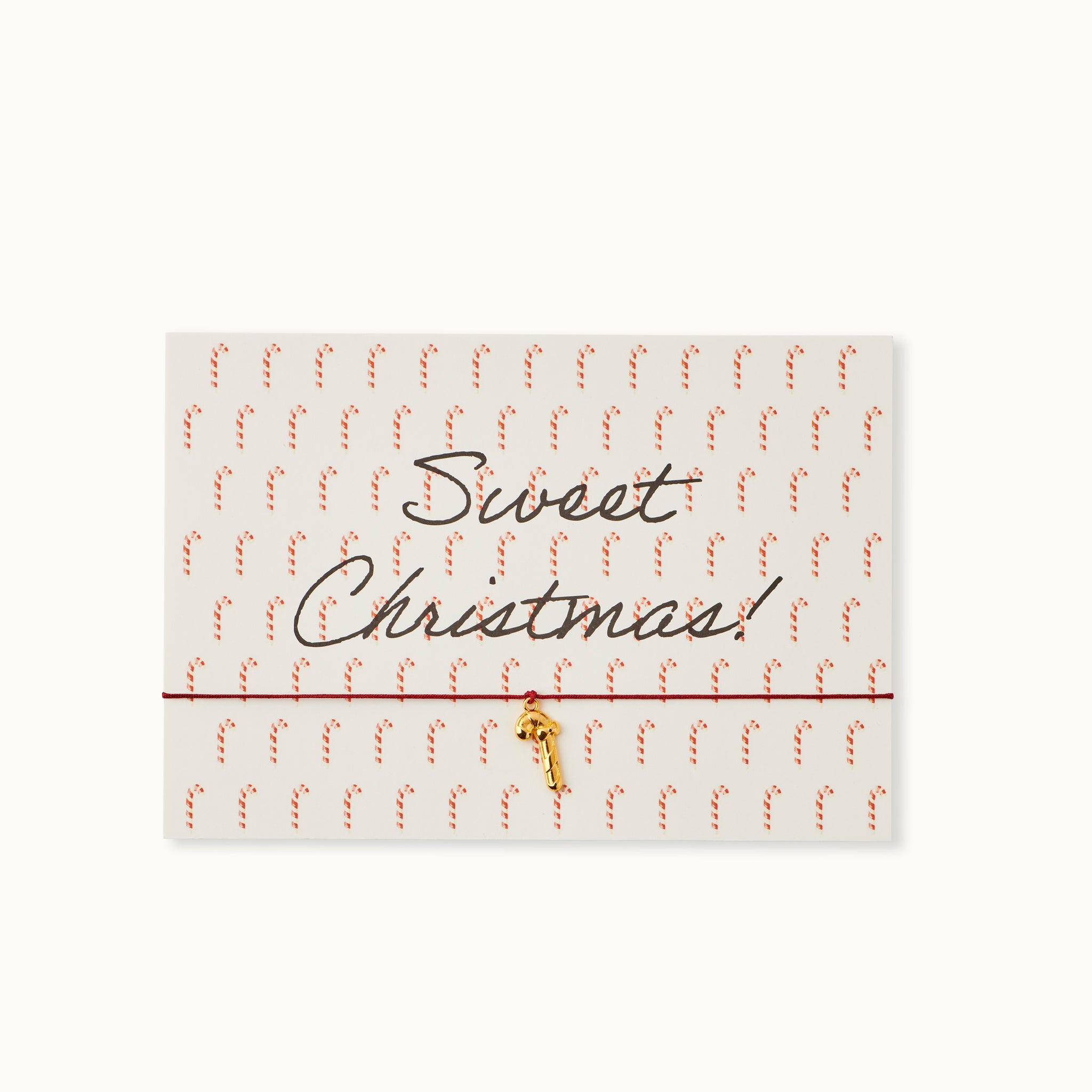 Sweet Christmas! Karte mit einer Zuckerstange als 18K vergoldeter Anhänger an einem dunkelroten Armband.