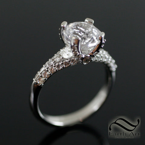 Custom engagement ring featuring diamonds and a white sapphire center stone.