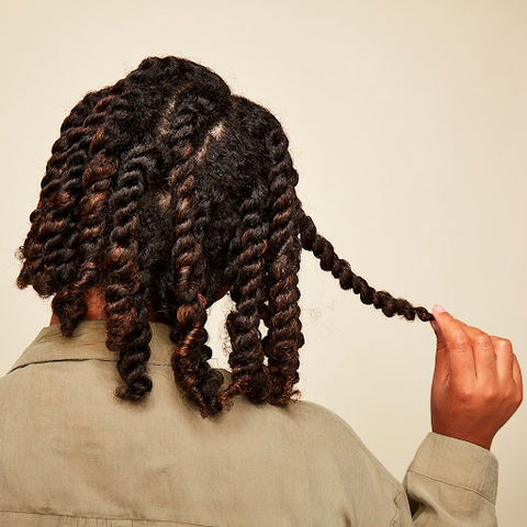 A person with 4C hair uses two-strand twists as a gentle protective style.