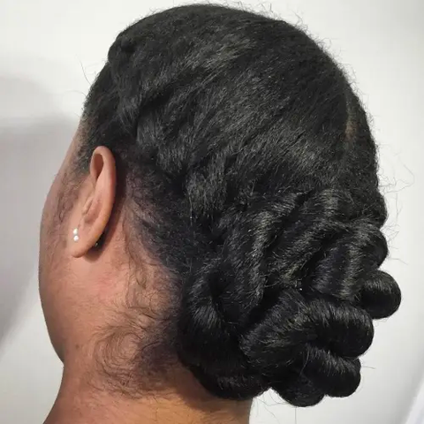 A black woman with a twist chignon protective style.
