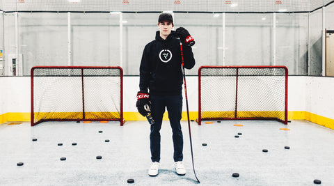 Josh Doan, NHL Prospect & Enduraphin Athlete, stands atop the ice with his hockey stick and an Athletic Fuel.