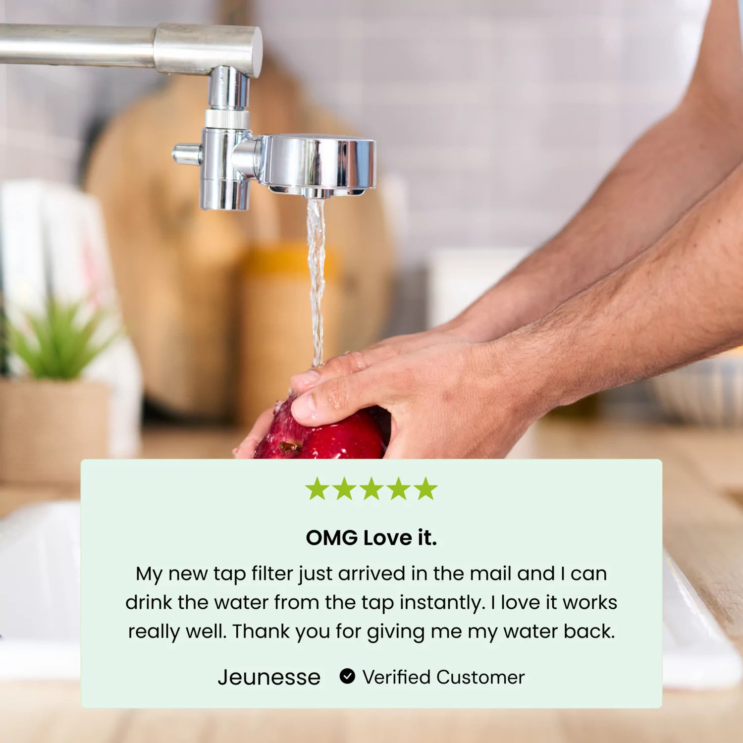 Person washing fruit under a tap with an attached water filter, customer review displayed below.