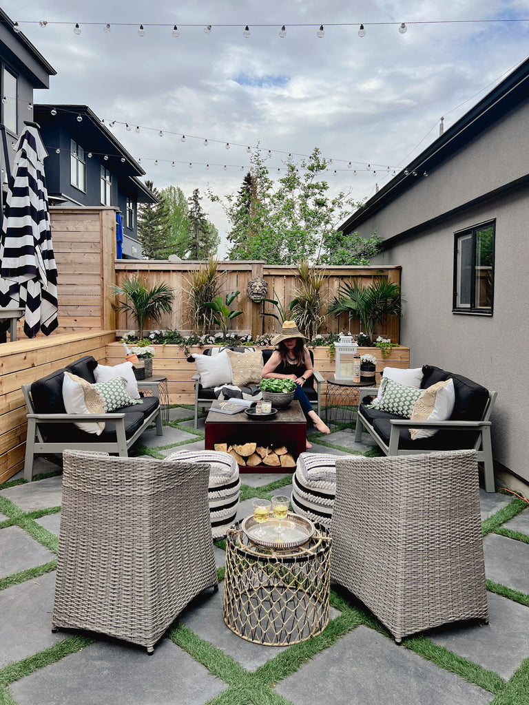 Outdoor livingroom with stone tiles, grass between stone tiles, small inner city yard