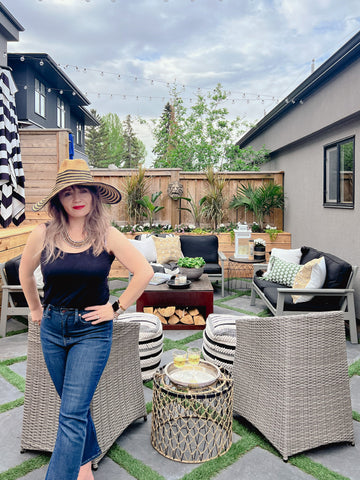 Heather Draper in her outdoor living room "the oasis" featuring diamond pavers with artificial grass. furnishing from ikea and 2022 outdoor decor trend ideas and outdoor styling tips