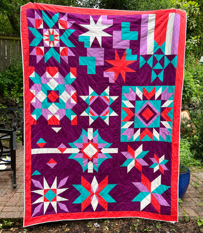 Quilt Camp 2022 quilt, a red, purple, teal, and white quilt