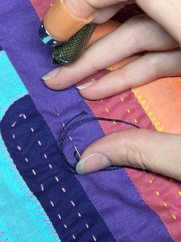 Three stitches are formed as the needle passes through the quilt.