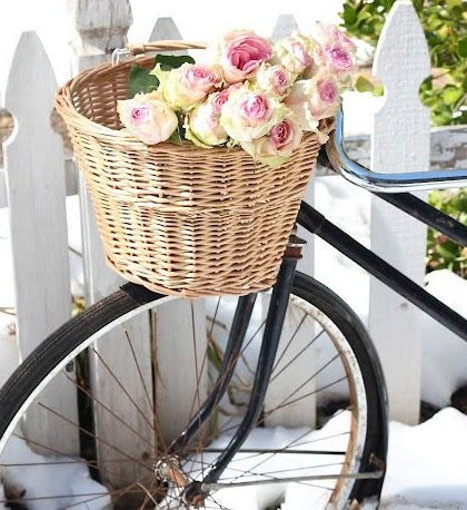 Bicycle with a front basket filled with roses