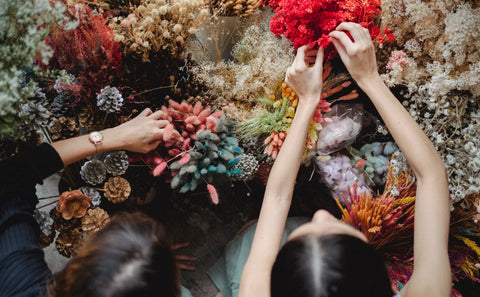 a picture of two women that are busy choosing flowers