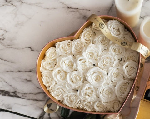 set of preserved white roses in a heart shape container