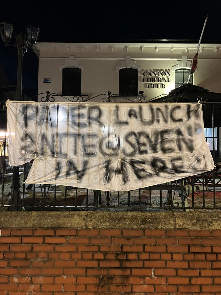 Hand painted banner reads ‘Paper launch 2nite @ seven in here’