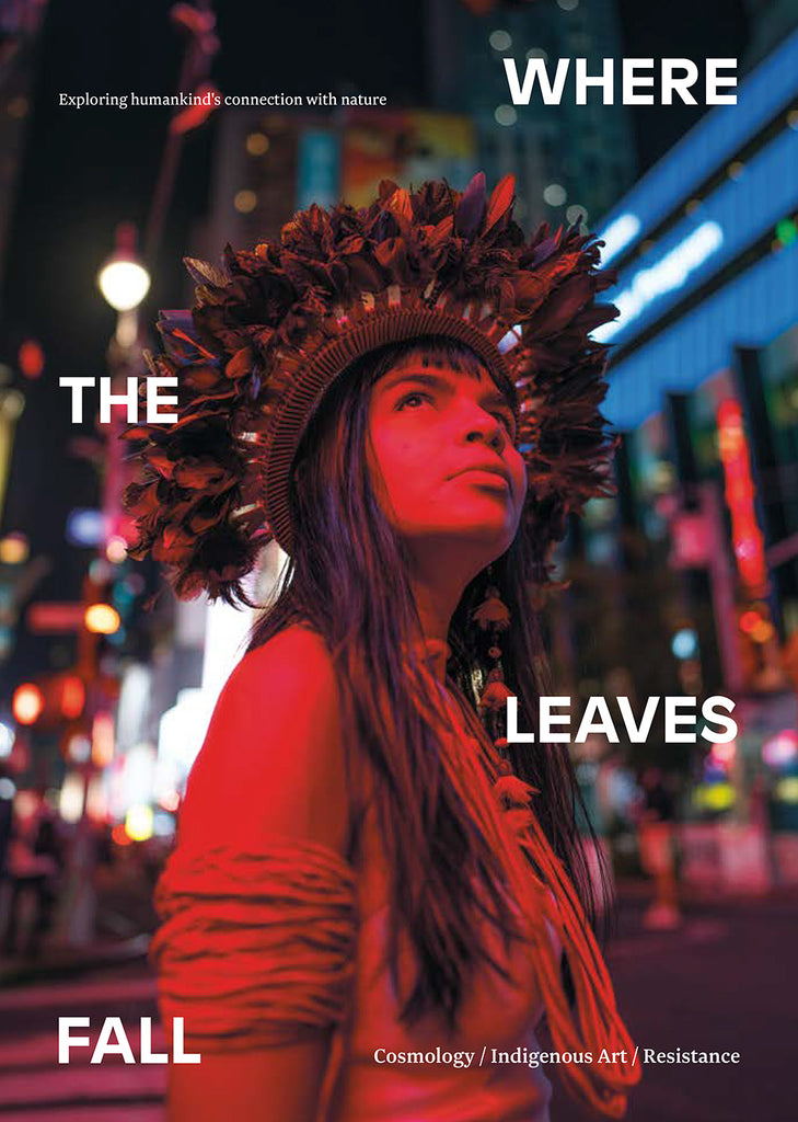 Magazine cover; woman in headdress stands in dark street with red light across her.