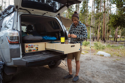 Man Preparing Coffee with EcoSimmer in trunk of car when car camping