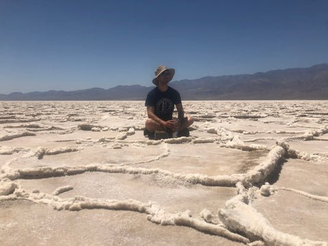 Man sitting in salt flats of Death Valley