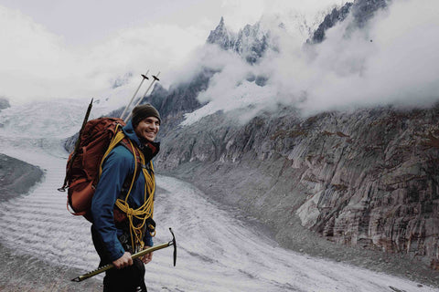Man backpacking on glacier with axe and other equipment