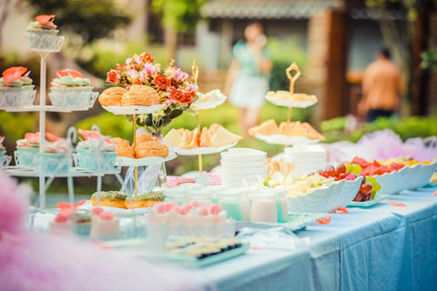 Table de fête en extérieure avec des pâtisserie et des gâteaux