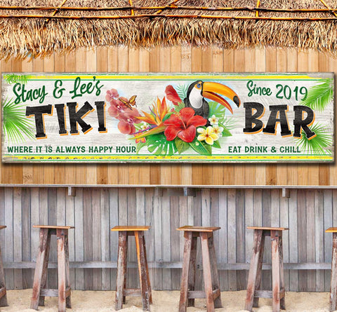 Tiki Bar Sign on faux distressed beach wood with personalized family name, established date, Toucan Bird and tropical foliage in the center of the signs. Tiki Bar sign reads "where it is always happy hour. Eat drink & chill".  