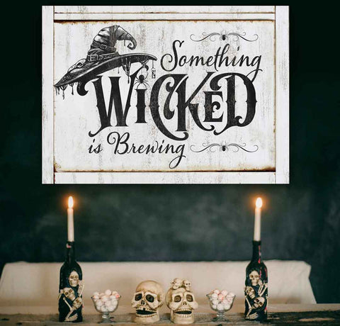 Halloween decor for walls, rustic faux white wood canvas overlayed with black witch had and spooky font that reads "something wicked is brewing". 