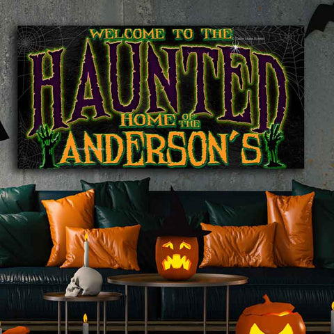 Haunted Halloween Wall Art. Says Welcome to the haunted home of your family name. Green and purple spooky fond on black canvas. 