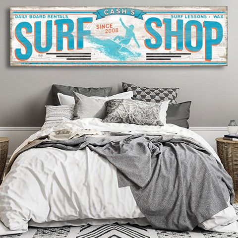 Surfer boy room ideas, Surf Shop Sign with a surfer in teal blue on the wall behind a teen bed