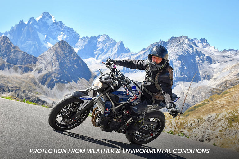 a male bike rider is wearing a motorcycle suit while riding in snowy area.