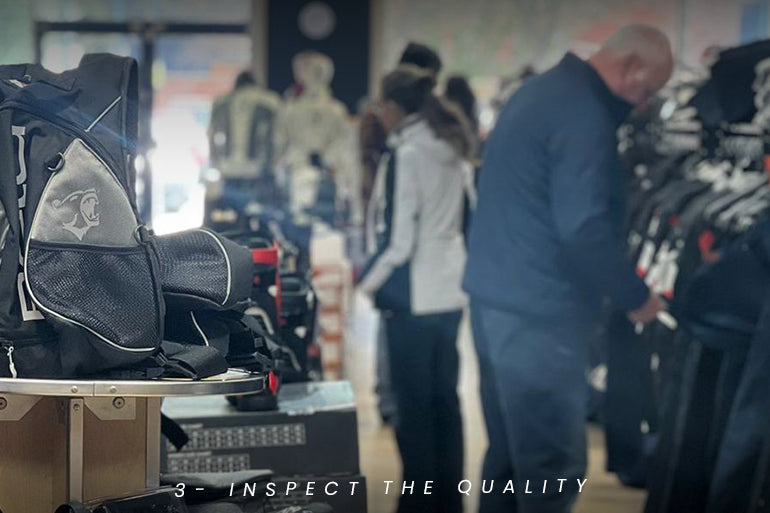 a scene inside Maximo Moto motorcycle gear store at Astle Park, depicting a customer evaluating motorcycle equipment.