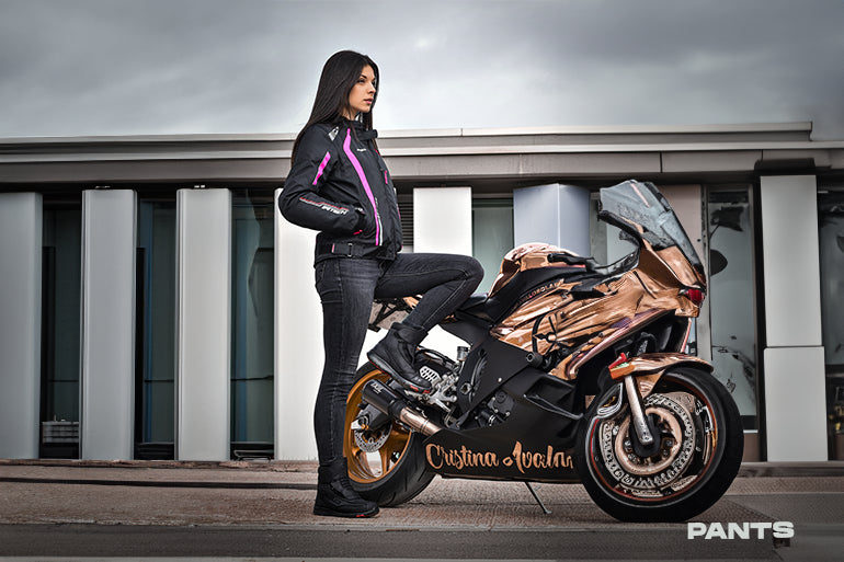 a female rider is wearing maximo moto bela motorcycle pant
