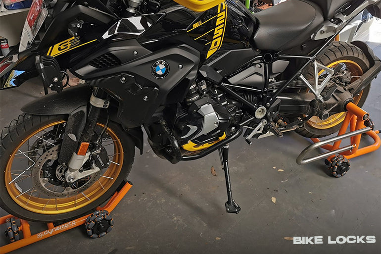 A modern motorbike is parked in a well-lit setting, securely fastened with a heavy-duty security lock.