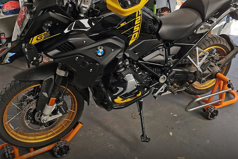 A motorcycle standing upright on a durable black-colored stand.