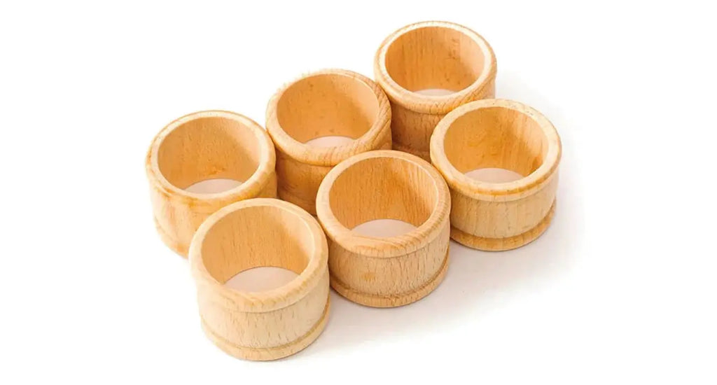 Rustic wooden napkin rings holding linen napkins at elegant farmhouse table setting