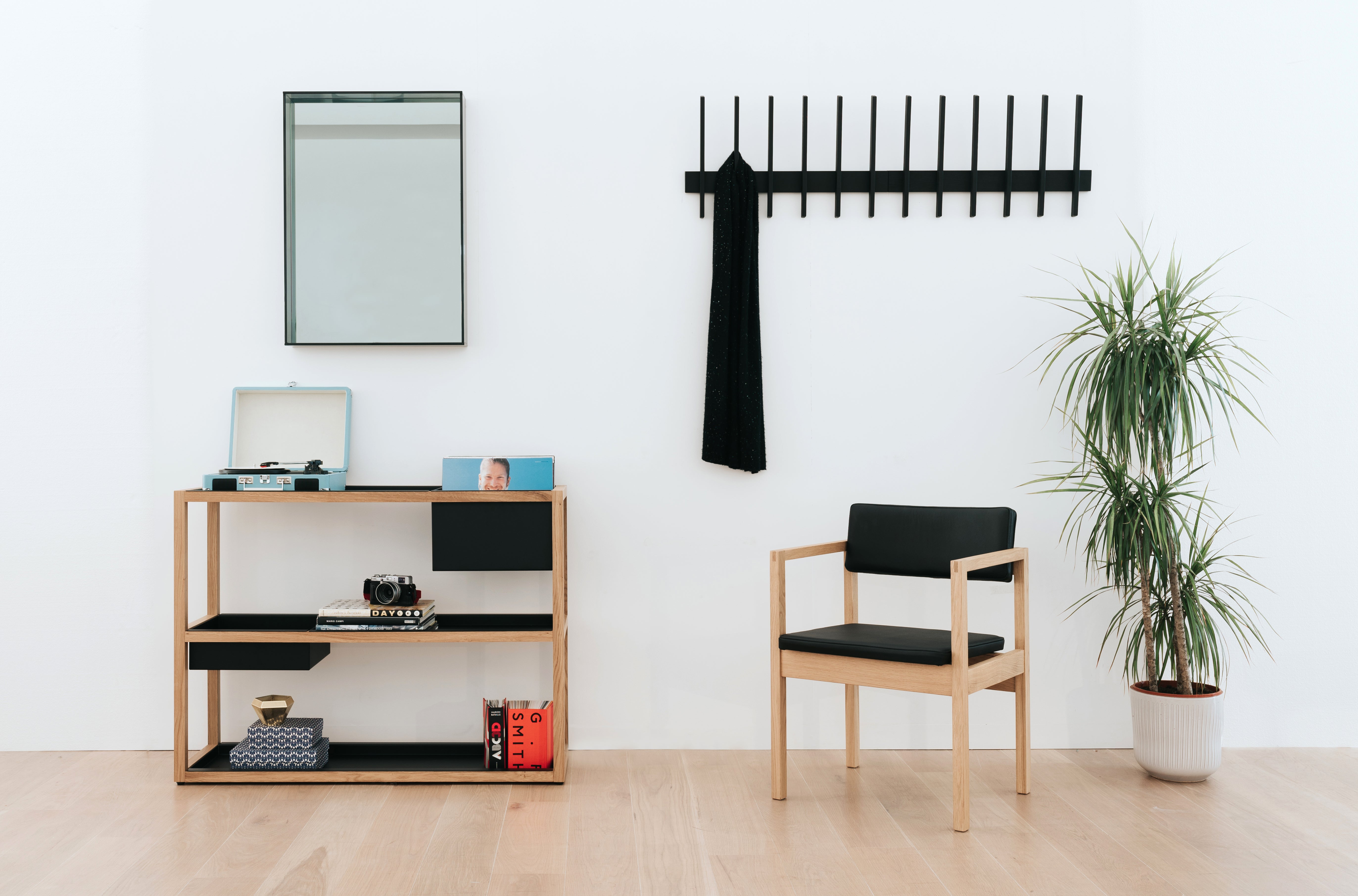 room with shelving, a chair, wall mirror and wall hooks