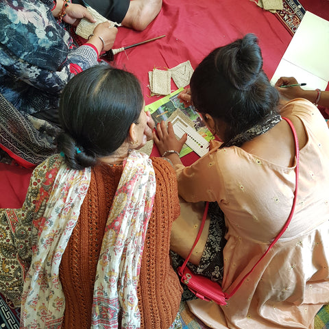 artisan women in India discuss knitting patterns